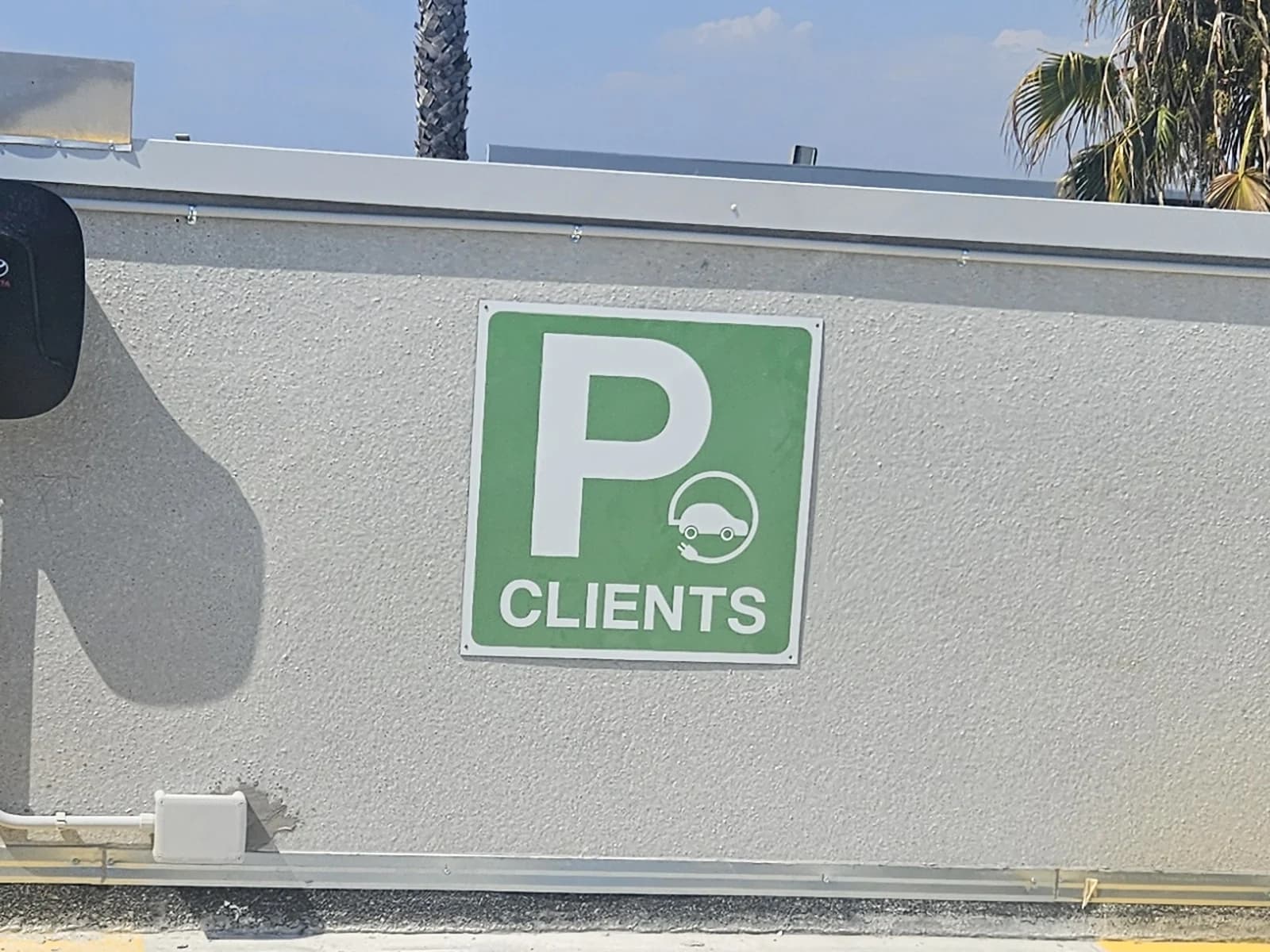 Placa verde de Autocam con el símbolo de aparcamiento en la fachada.