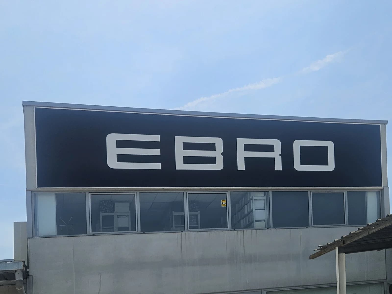 Rótulo EBRO con letras blancas sobre un panel negro en el concesionario.