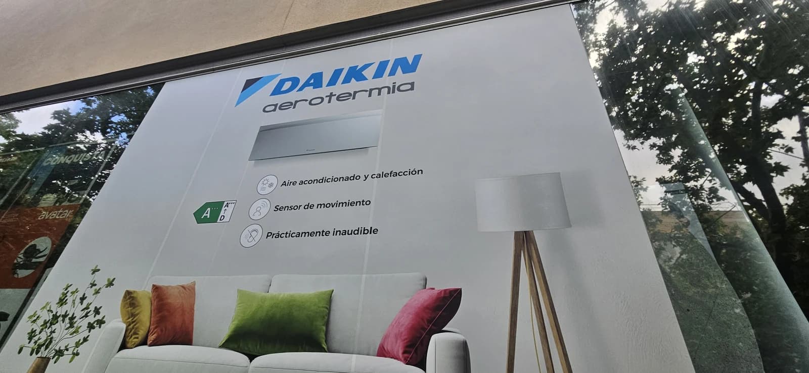 Vista parcial del gráfico Daikin en el escaparate de Milar Morató, con el logotipo y la ilustración de un interior.