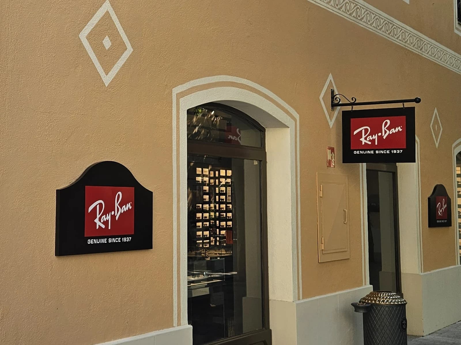 Placa de pared y banderola de Ray-Ban junto a la entrada.